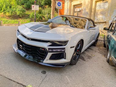 Gümüşten bir Chevrolet Corvette 'in sonbaharda şehir sokağında park halindeki görüntüsü. Otomobil tasarım özellikleri, ızgara deseni, amblem, kaput delikleri ve LED h Kyiv, Ukrayna, 06-15-2024