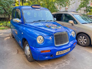 Gündüz vakti hasarlı eski model bir taksi dışarıda park halinde, sessiz bir ortamda görüntüler çok az insan faaliyeti ile görüntüyü yakalıyor ve Kyiv, Ukrayna, 06-15-2024