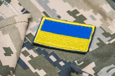 Ukrayna ordusunun askeri üniformasında Ukrayna bayrağı. Savaş ve silah malzemeleri kavramı. Pikselli ordu pettern militaria haki. Ukrayna ulusal sembolü ve savunma sembolü. Sarı-mavi