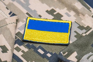 Ukrayna ordusunun askeri üniformasında Ukrayna bayrağı. Savaş ve silah malzemeleri kavramı. Pikselli ordu pettern militaria haki. Ukrayna ulusal sembolü ve savunma sembolü. Sarı-mavi