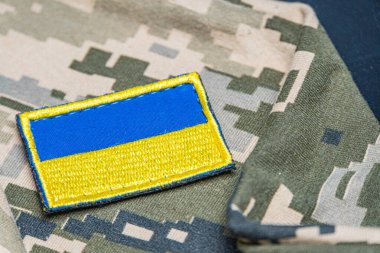 Ukrayna ordusunun askeri üniformasında Ukrayna bayrağı. Savaş ve silah malzemeleri kavramı. Pikselli ordu pettern militaria haki. Ukrayna ulusal sembolü ve savunma sembolü. Sarı-mavi