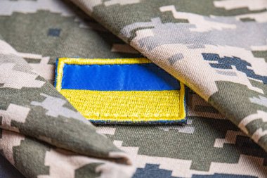 Ukrayna ordusunun askeri üniformasında Ukrayna bayrağı. Savaş ve silah malzemeleri kavramı. Pikselli ordu pettern militaria haki. Ukrayna ulusal sembolü ve savunma sembolü. Sarı-mavi