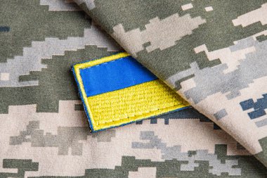 Ukrayna ordusunun askeri üniformasında Ukrayna bayrağı. Savaş ve silah malzemeleri kavramı. Pikselli ordu pettern militaria haki. Ukrayna ulusal sembolü ve savunma sembolü. Sarı-mavi