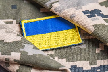 Ukrayna ordusunun askeri üniformasında Ukrayna bayrağı. Savaş ve silah malzemeleri kavramı. Pikselli ordu pettern militaria haki. Ukrayna ulusal sembolü ve savunma sembolü. Sarı-mavi