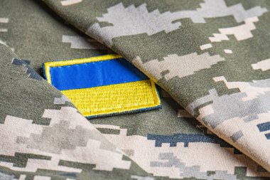 Ukrayna ordusunun askeri üniformasında Ukrayna bayrağı. Savaş ve silah malzemeleri kavramı. Pikselli ordu pettern militaria haki. Ukrayna ulusal sembolü ve savunma sembolü. Sarı-mavi