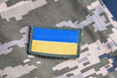 Ukrayna ordusunun askeri üniformasında Ukrayna bayrağı. Savaş ve silah malzemeleri kavramı. Pikselli ordu pettern militaria haki. Ukrayna ulusal sembolü ve savunma sembolü. Sarı-mavi