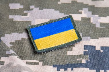 Ukrayna ordusunun askeri üniformasında Ukrayna bayrağı. Savaş ve silah malzemeleri kavramı. Pikselli ordu pettern militaria haki. Ukrayna ulusal sembolü ve savunma sembolü. Sarı-mavi
