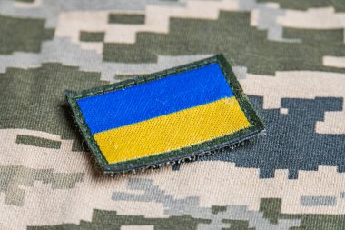 Ukrayna ordusunun askeri üniformasında Ukrayna bayrağı. Savaş ve silah malzemeleri kavramı. Pikselli ordu pettern militaria haki. Ukrayna ulusal sembolü ve savunma sembolü. Sarı-mavi