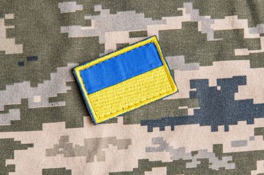 Ukrayna ordusunun askeri üniformasında Ukrayna bayrağı. Savaş ve silah malzemeleri kavramı. Pikselli ordu pettern militaria haki. Ukrayna ulusal sembolü ve savunma sembolü. Sarı-mavi