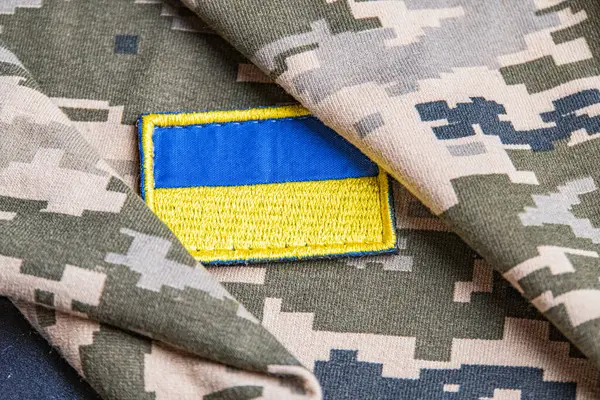 Ukrayna ordusunun askeri üniformasında Ukrayna bayrağı. Savaş ve silah malzemeleri kavramı. Pikselli ordu pettern militaria haki. Ukrayna ulusal sembolü ve savunma sembolü. Sarı-mavi