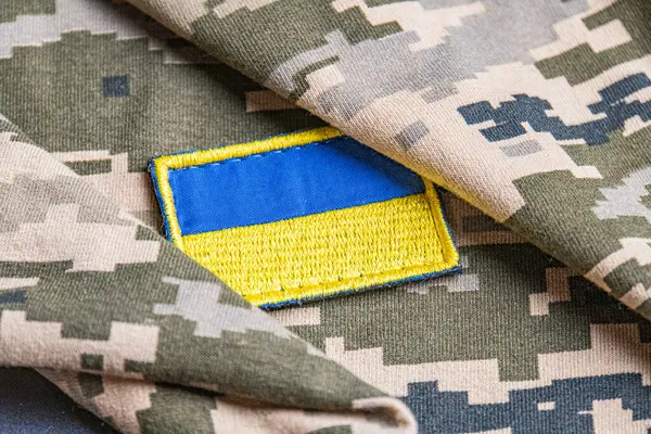 Ukrayna ordusunun askeri üniformasında Ukrayna bayrağı. Savaş ve silah malzemeleri kavramı. Pikselli ordu pettern militaria haki. Ukrayna ulusal sembolü ve savunma sembolü. Sarı-mavi