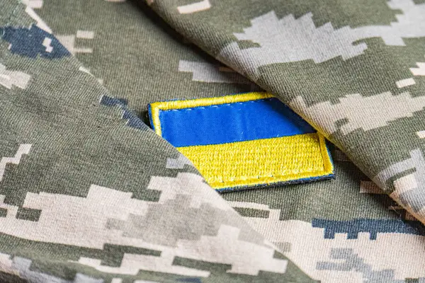 Ukrayna ordusunun askeri üniformasında Ukrayna bayrağı. Savaş ve silah malzemeleri kavramı. Pikselli ordu pettern militaria haki. Ukrayna ulusal sembolü ve savunma sembolü. Sarı-mavi