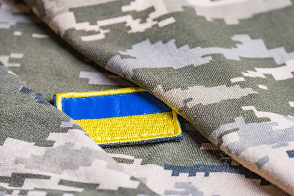 Ukrayna ordusunun askeri üniformasında Ukrayna bayrağı. Savaş ve silah malzemeleri kavramı. Pikselli ordu pettern militaria haki. Ukrayna ulusal sembolü ve savunma sembolü. Sarı-mavi