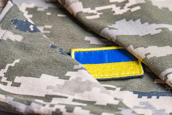 Ukrayna ordusunun askeri üniformasında Ukrayna bayrağı. Savaş ve silah malzemeleri kavramı. Pikselli ordu pettern militaria haki. Ukrayna ulusal sembolü ve savunma sembolü. Sarı-mavi
