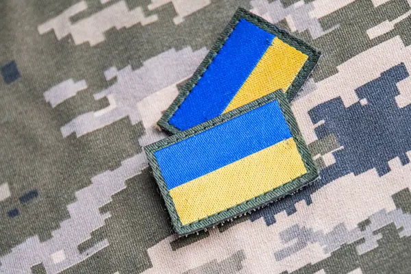 Ukrayna ordusunun askeri üniformasında Ukrayna bayrağı. Savaş ve silah malzemeleri kavramı. Pikselli ordu pettern militaria haki. Ukrayna ulusal sembolü ve savunma sembolü. Sarı-mavi