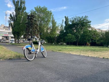 Parçalı bulutlu gökyüzünün altında park edilmiş bir şehir bisikleti, muhtemelen şehir parkında ya da yerleşim yerlerinde Kyiv, Ukrayna 06-02-2024