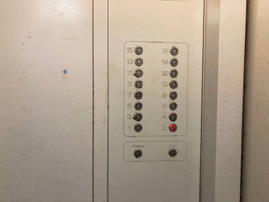 Ukrayna, Kyiv, Ukrayna 06-02-2024 'te iki sütuna ayrılmış, 1 ile 20 arasında değişen düğmeleri olan yıpranmış bir metal asansör kontrol panelinin yakın plan resmi bulunmaktadır.