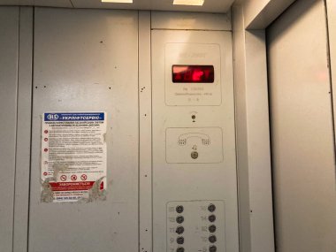 Görüntü, Rus etiketli bir işletim asansörü, kırmızı uyarı ışığı ve metal panelli asansör şaftı Kyiv, Ukrayna 06-02-2024 'ü gösteriyor.