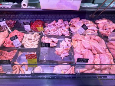 Tavuklar, tavuk parçaları, domuz kıyması, sosisler, h Kyiv, Ukrayna 11-02-2024 gibi çeşitli et türleri ve paketleriyle iyi ışıklandırılmış bir et vitrininin resmi.