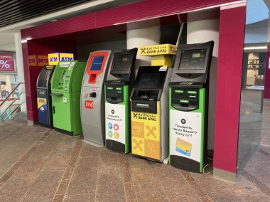 Görüntü kapalı bir alanda veya ulaşım merkezinde ATM ekranlarında talimatlar ve Kyiv, Ukrayna 11-02-2024 'ü gösteren bir dizi renkli ATM tasvir ediyor.