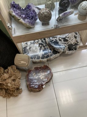 Image displays a collection of decorative items, including tumbled stones, spheres or eggs, and potential fossils in a shop The display is casual, with haphazardly arran Kyiv, Ukraine 11-02-2024 clipart