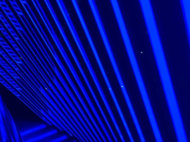 Yukarıdan gelen bir ışık kaynağı ile soyut mavi geometrik desen, muhtemelen aydınlatılmış bir yapı ya da mekan tasvir ediyor. a