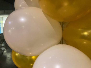 Bir grup çok renkli balon, altın, beyaz, şeffaf, kapalı bir ortamda muhtemelen kutlama için. a