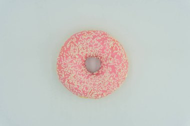 Merkezli, hafif açılı, pembe jöleli ve hafif bir yüzeye serpiştirilmiş bir çörek. Basit kompozisyonda dikkat dağıtıcı bir şey yok.