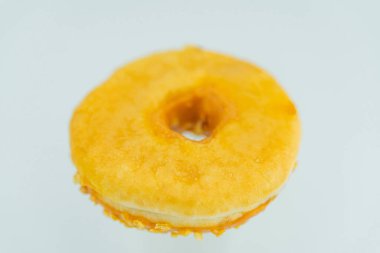 Bulanık bir arka planda, altın-kahverengi, yeni pişmiş bir çöreğin odaklanmış bir görüntüsü.