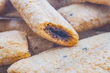 Çok sayıda krakerin yakın plan görüntüsü, koyu dolgulu, muhtemelen çikolata ya da karamel rengi kahverengi, içi erimiş kraker ve torba içindeki diğer krakerlere odaklanmış.