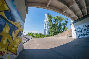 Image shows a multi-story parking garage with graffiti and greenery, showcasing functional design for vehicle traffic and space used as an urban canvas for art Kyiv, Ukraine 06-17-2024 clipart