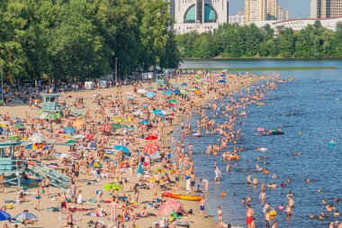 Yüzme havuzları ve iyi organize edilmiş dinlenme alanları da dahil olmak üzere modern mimari faaliyetleri sunan canlı bir sahil manzarası insan etkinliği Kyiv, Ukrayna 06-17-2024 'ü resmediyor.