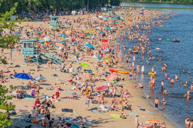 Sahile gelenlere gölgelik sağlayan renkli kabinlerle dolu canlı bir plaj sahnesi, Kyiv, Ukrayna 06-17-2024 mimarisinin iyi korunmuş bir halk plajını resmediyor.