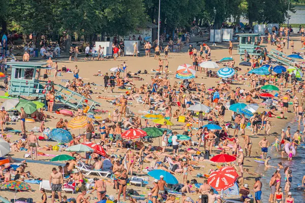 Renkli şemsiyeli canlı sahil manzarası, bir tahta kaldırım, ve küçük binalar Ağaçlar ve kum Kyiv, Ukrayna 06-17-2024