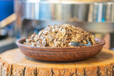 Görüntü ahşap bir kesim tahtası ve bir kase doğranmış sebze gösteriyor, muhtemelen sarımsak, ev ortamında yumuşak yapay ışıklandırma altında.