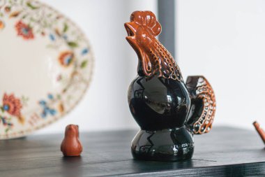 Bir resimde, muhtemelen Ukrayna veya Crimea 'dan gelen antika seramik koleksiyonu, kahverengi bir horoz heykelciği ve çiçek desenli diğer parçaların yer aldığı Kyiv, Ukrayna 03-01-2025