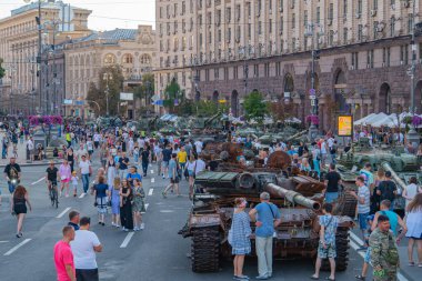 Sivil faaliyetlerin ortasında zırhlı araç MBT veya APC, çatışma hazırlığı veya askeri harekâta işaret eden şehir merkezinde park halinde bulunuyor. Görüntü Kyiv, Ukrayna 08-24-2024