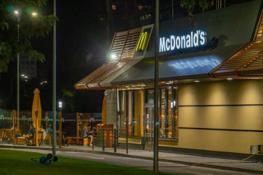 Gece vakti McDonalds restoranının görüntüsü, altın kemerler ve dış ışıklarla potansiyel olarak jeopolitik gerilimlerin ticaret ve c Kyiv, Ukrayna 08-24-2024 üzerindeki ekonomik etkisini tartışmak için uygun.