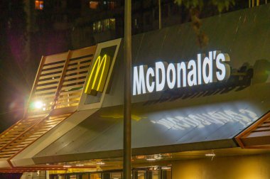McDonalds 'ın altın kemerler, McDonalds' ın işaretli metni imzaladığı gece görüntüsü. Rus-Ukrayna çatışması Kyiv, Ukrayna 08-24-2024