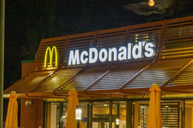 Görüntü modern mimari ve aydınlatma işaretli bir McDonalds restoranını gösteriyor. Askeri varlık, silah veya çatışma yok. Kyiv, Ukrayna 08-24-2024