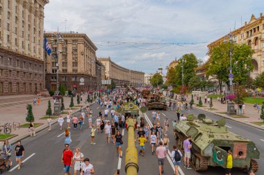 Görüntü, muhtemelen bir olayı kutlayan veya ana savaş tankları Kyiv, Ukrayna 08-24-2024 gibi modern askeri teçhizatlı zırhlı araçların sergilendiği bir şehir ortamında askeri geçit töreni veya sergi gösteriyor.