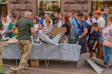 Bir grup birey, Kyiv, Ukrayna 08-24-2024 açık hava sahasında askeri teknolojiyi, muhtemelen İHA 'ları veya diğer hava sistemlerini tartışıyor.