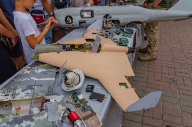 Parçalanmış bir insansız hava aracı, insansız hava aracı teknolojisi sergilenen bir masada sergileniyor. İçerik, Kyiv, Ukrayna 08-24-2024 ile birlikte havacılık veya savunma teknolojilerine odaklanmış bir halk toplantısı öneriyor.