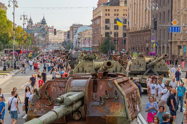 Görüntü, büyük olasılıkla bir sergi veya savaş tarihiyle ilgili bir anma etkinliğinde Avrupa askeri tankları ve topçu parçalarının bir şehir ortamında sergilenişini gösteriyor.