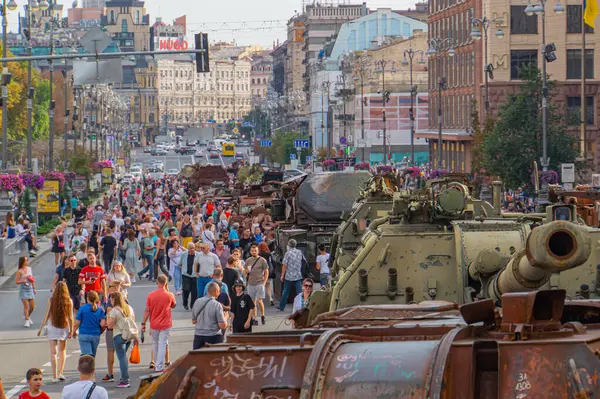 Görüntü, muhtemelen Rusya-Ukrayna çatışmalarıyla ilgili bir şehir ortamında MBT 'li bir askeri konvoyu gösteriyor. İki zırhlı savaş aracı ve sivil gözlem aracı Kyiv, Ukrayna 08-24-2024