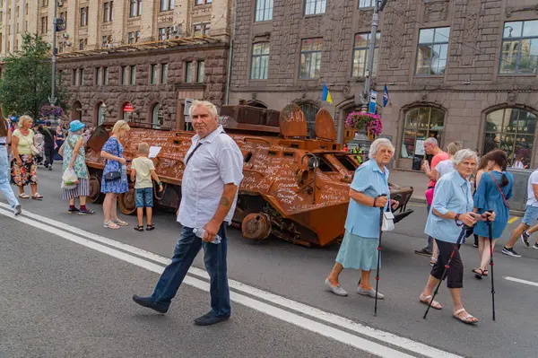 Aralarında bir adamın yürüyüp gitmesi ve iki yaşlı kadının bir yürüteçle caddeden karşıya geçmesinin de yer aldığı şehir manzarası şehir bui Kyiv, Ukrayna 08-24-2024