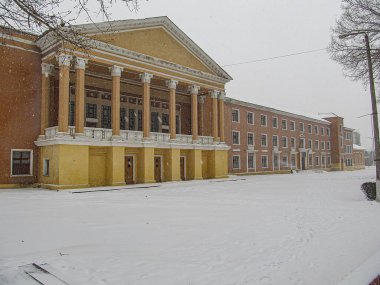 Klasik mimari özelliklere sahip büyük, karla kaplı bir binanın resmi, muhtemelen bir kurum veya kamu binası, kışın gökyüzü bulutlu Kostiantynivka, Ukrayna, 01-15-2013