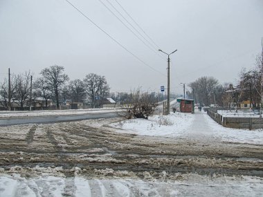 Kar yağan kış manzarası, yeni araç rayları, yol, binalar, üstgeçit, bulutlu gökyüzü elektrik direği, kablolar, kumlu doku Kostiantynivka, Ukrayna, 01-15-2013
