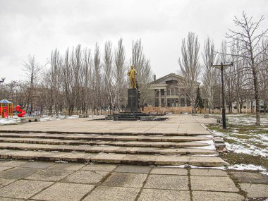 Ağaçlar ve binalarla çevrili, bulutlu bir gökyüzünün altında, iyi korunmuş bir halk meydanının sakin bir görüntüsü. Sahne, kış ya da sonbahar Kostiantynivka, Ukrayna, 01-15-2013