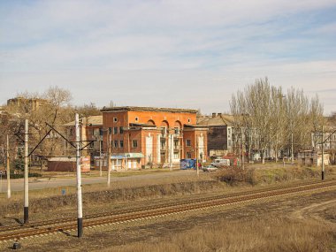 Endüstriyel binalarla gündüz görüntüsü, kırmızı cepheli ve kavisli gökyüzü, bitki örtüsü sonbaharın sonlarında, tra Kostiantynivka, Ukrayna, 01-15-2013